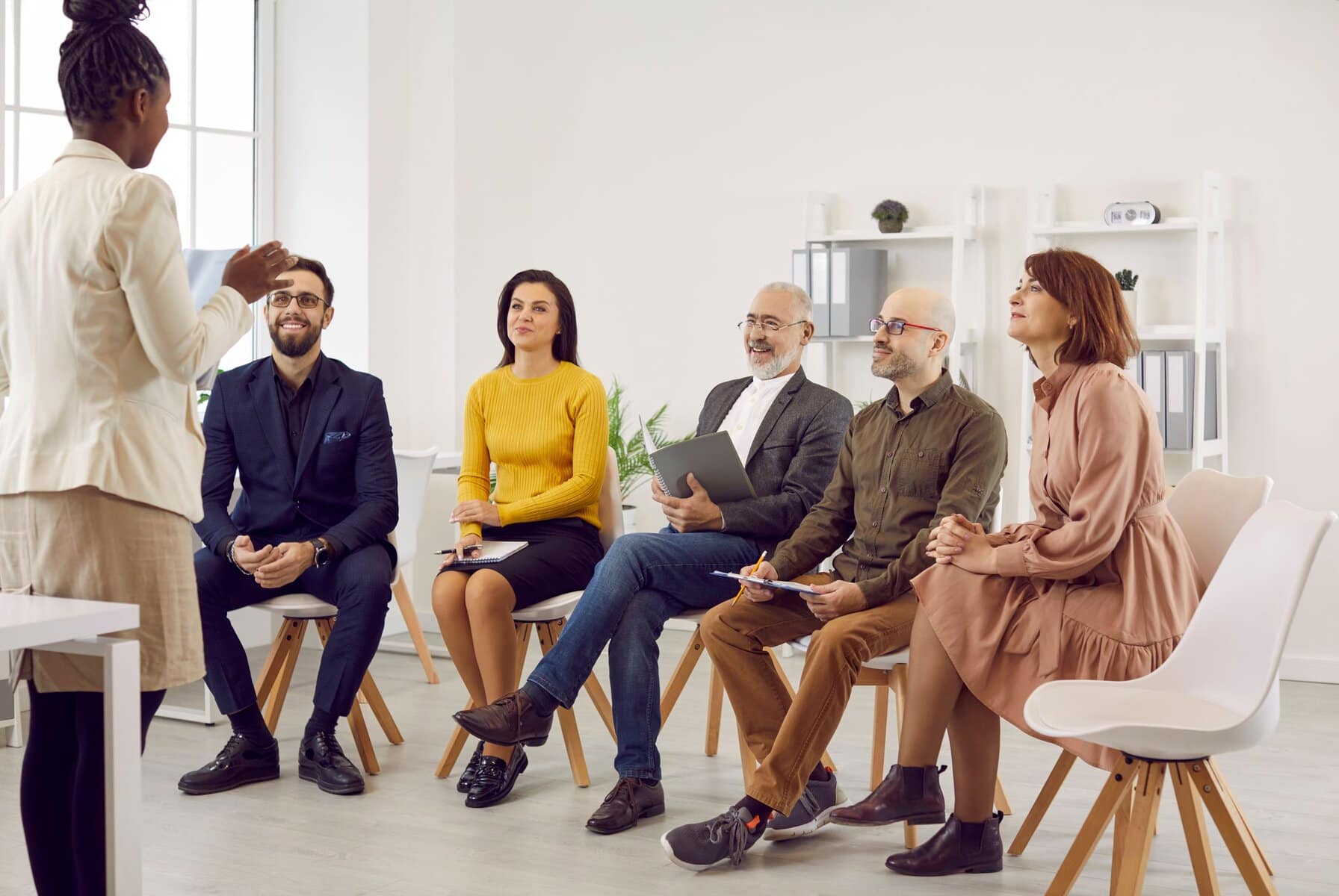 Female business coach speaks in front of small group