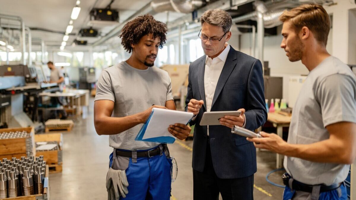 Factory worker reviewing reports with HR manager